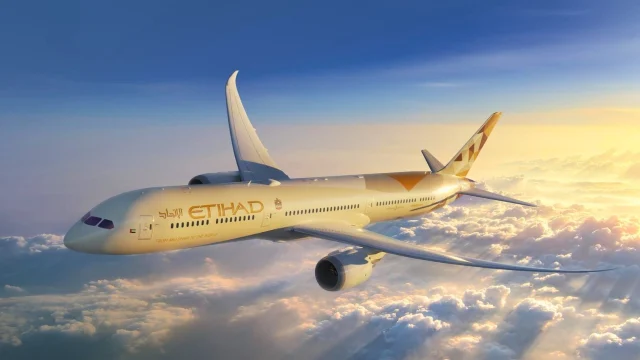 Etihad Airways aircraft flying above the clouds, representing premium travel and global flight connections.