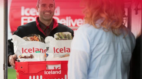 Iceland Groceries store front with bright signage, promoting affordable food deals and frozen meal savings.