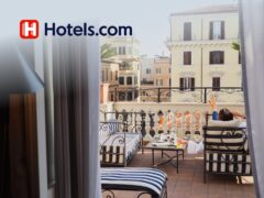 Person holding a smartphone showing Hotels.com app with a 10% discount offer for travel bookings and hotel deals.