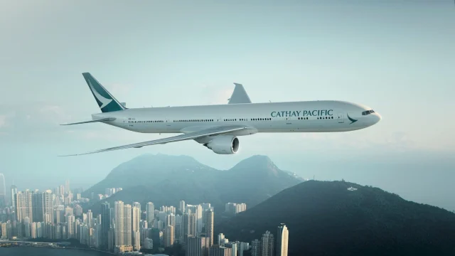 Cathay Pacific aircraft parked at an airport terminal, representing premium international travel and flight services.