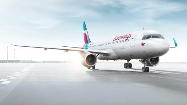 Eurowings aircraft parked at a European airport terminal, representing budget air travel and holiday flight bookings.
