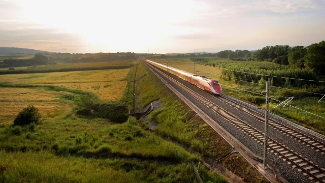 High-speed train travelling through the scenic Italian countryside, representing ItaliaRail travel and holiday bookings.