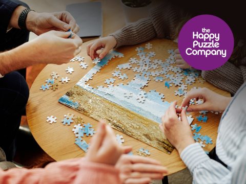 Happy Puzzle Company Happy Puzzle Company puzzle box cover featuring a colorful image of children playing with jigsaw puzzles and a family enjoying a puzzle game.