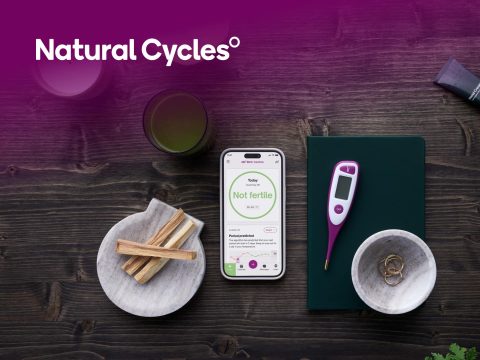 Natural Cycles app on a smartphone displaying fertility tracking data. Period cycle and ovulation monitoring for women's health.
