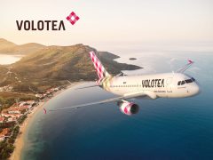 Volotea aircraft flying over a sunny landscape. Cheap flights and travel deals from Volotea. Book your next adventure!