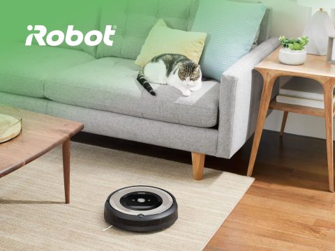 iRobot Roomba vacuum cleaner cleaning a hardwood floor. Smart home technology for automated cleaning. iRobot brand.