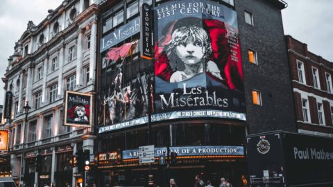 London’s Top Musicals: Discover West End Shows & Cheap Tickets Facade of Sondheim Theatre in London displaying Les Misérables posters.