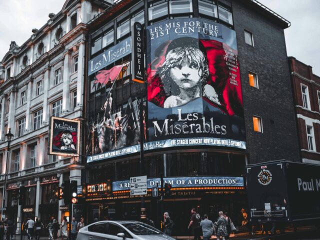 Facade of Sondheim Theatre in London displaying Les Misérables posters.