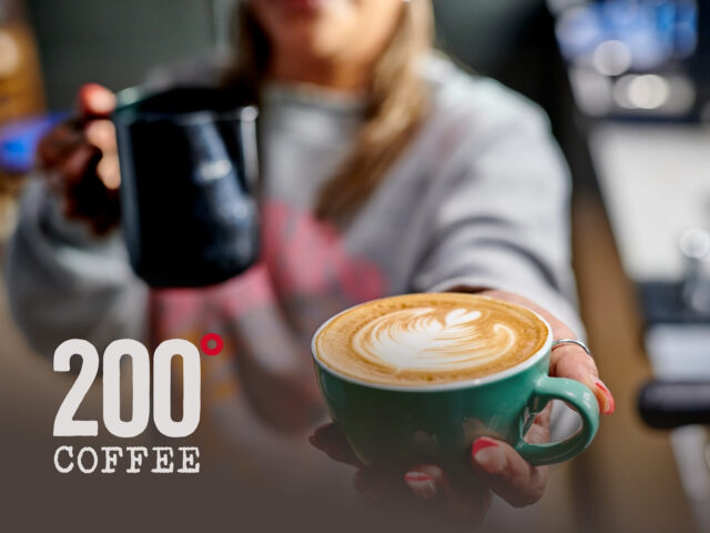 Barista pouring latte art at a 200 Degrees Coffee shop, featuring speciality roasted beans and premium espresso.