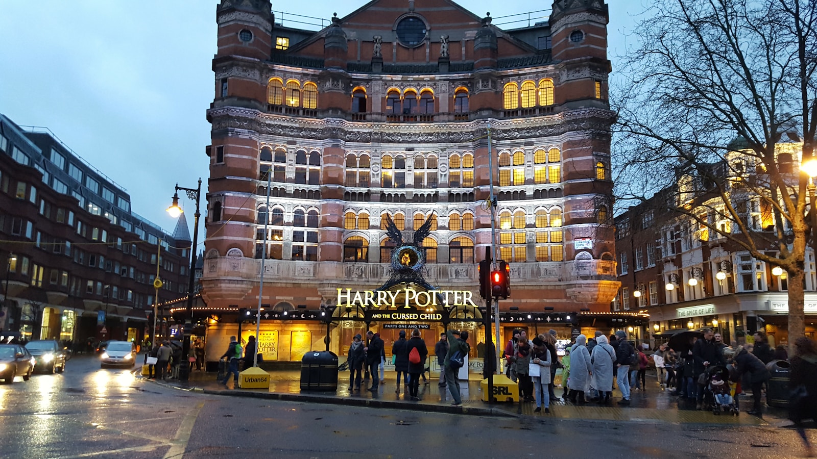 Illuminated Victorian terracotta facade of the Palace Theatre on Cambridge Circus featuring Harry Potter and the Cursed Child