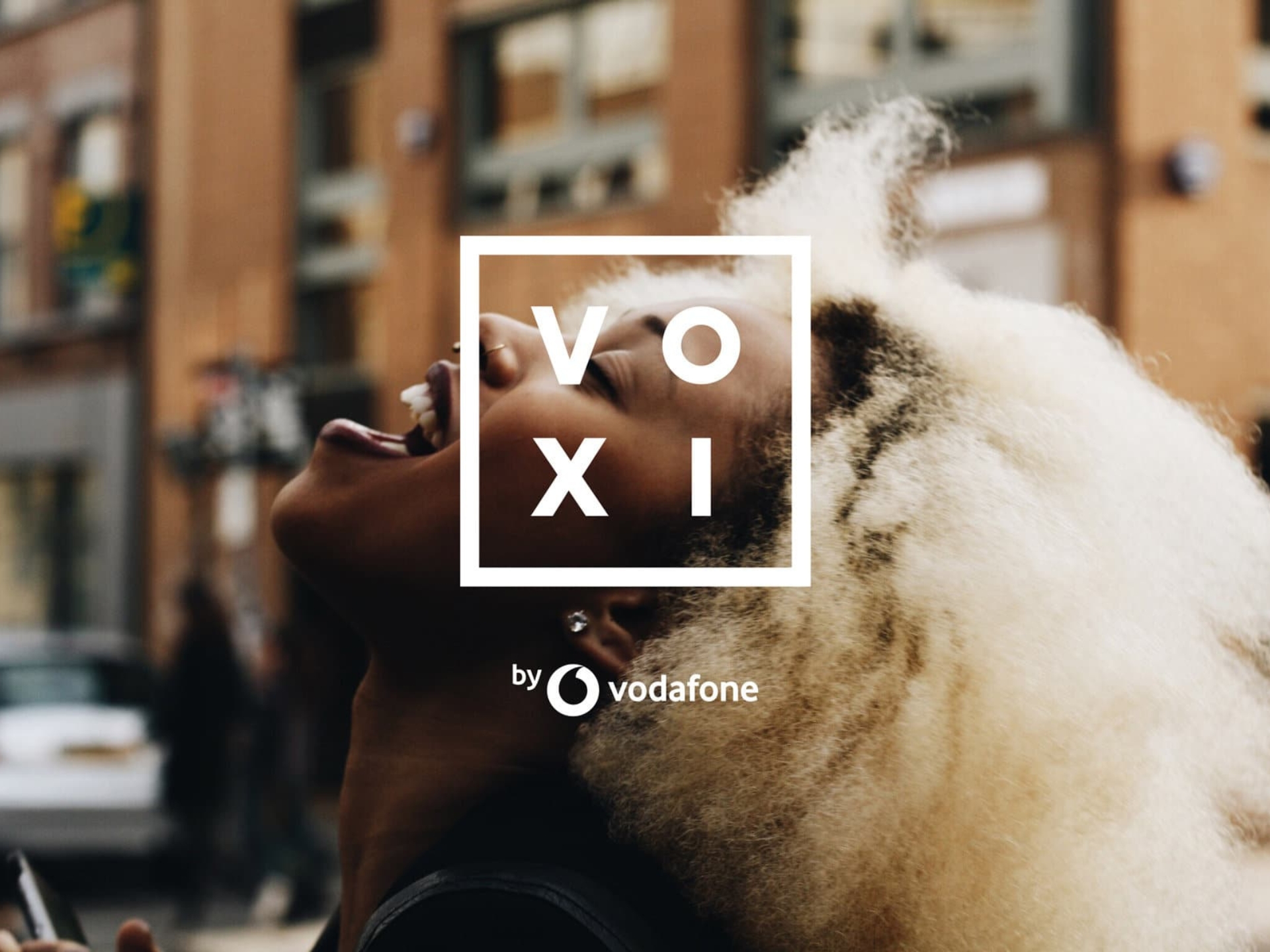 Young person using a smartphone, showcasing VOXI as a budget-friendly Vodafone dupe for mobile data savings.