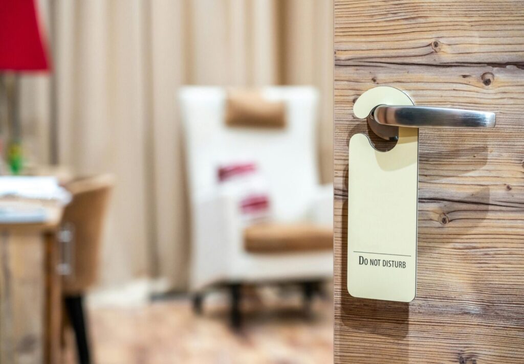 Hotel room door with 'Do Not Disturb' sign, symbolising privacy & relaxation. Perfect for luxury hotel deals & peaceful getaways.