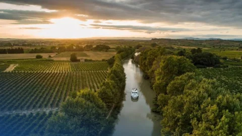 Le Boat luxury canal boat cruising through a scenic European waterway during a summer holiday getaway.