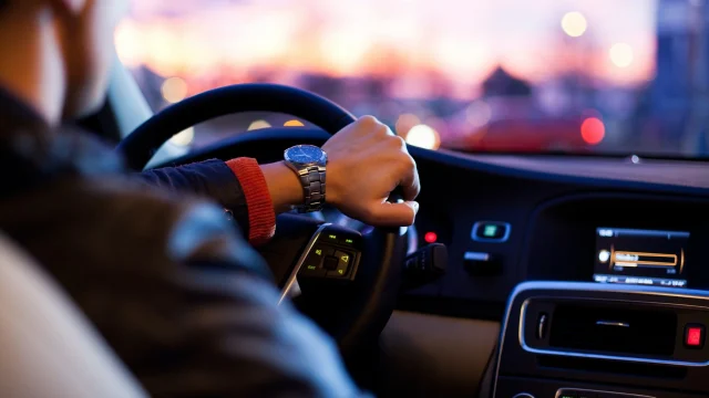 Avis UK car hire service featuring a modern vehicle parked at a city centre location for travel and holiday rentals.