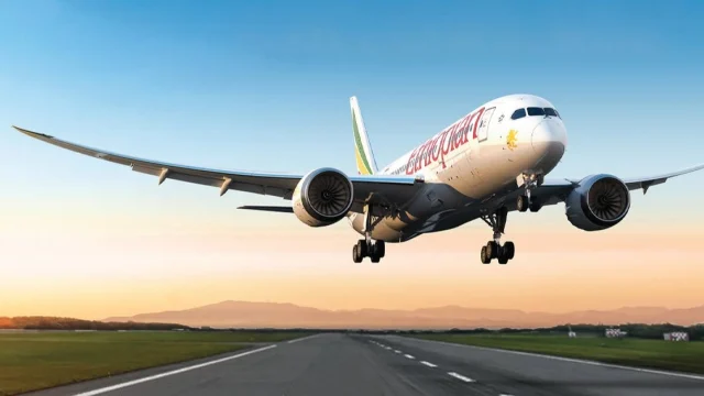 Ethiopian Airlines passenger aircraft taxiing at an international airport terminal for flight departures.