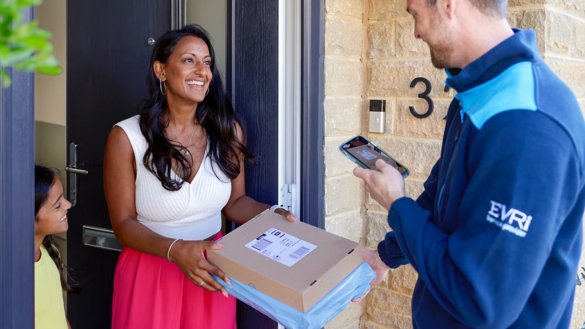 Evri courier delivering a parcel to a smiling customer at a UK residential doorstep
