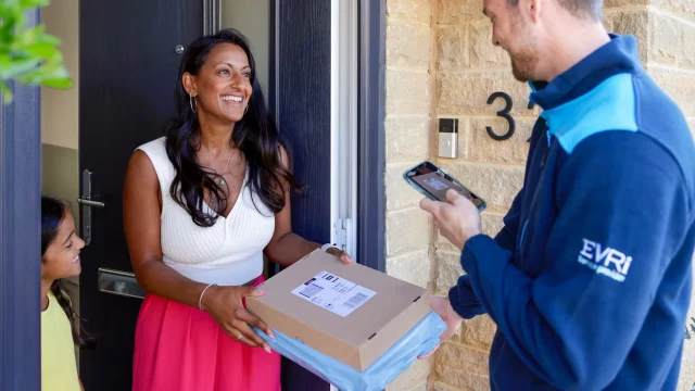 Evri parcel delivery courier delivering a package to a residential front door in the UK