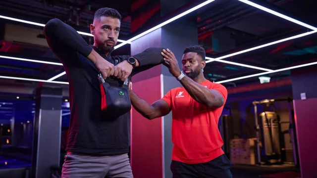 Fitness First gym members training in a modern, well-equipped exercise centre to improve health and physical fitness.
