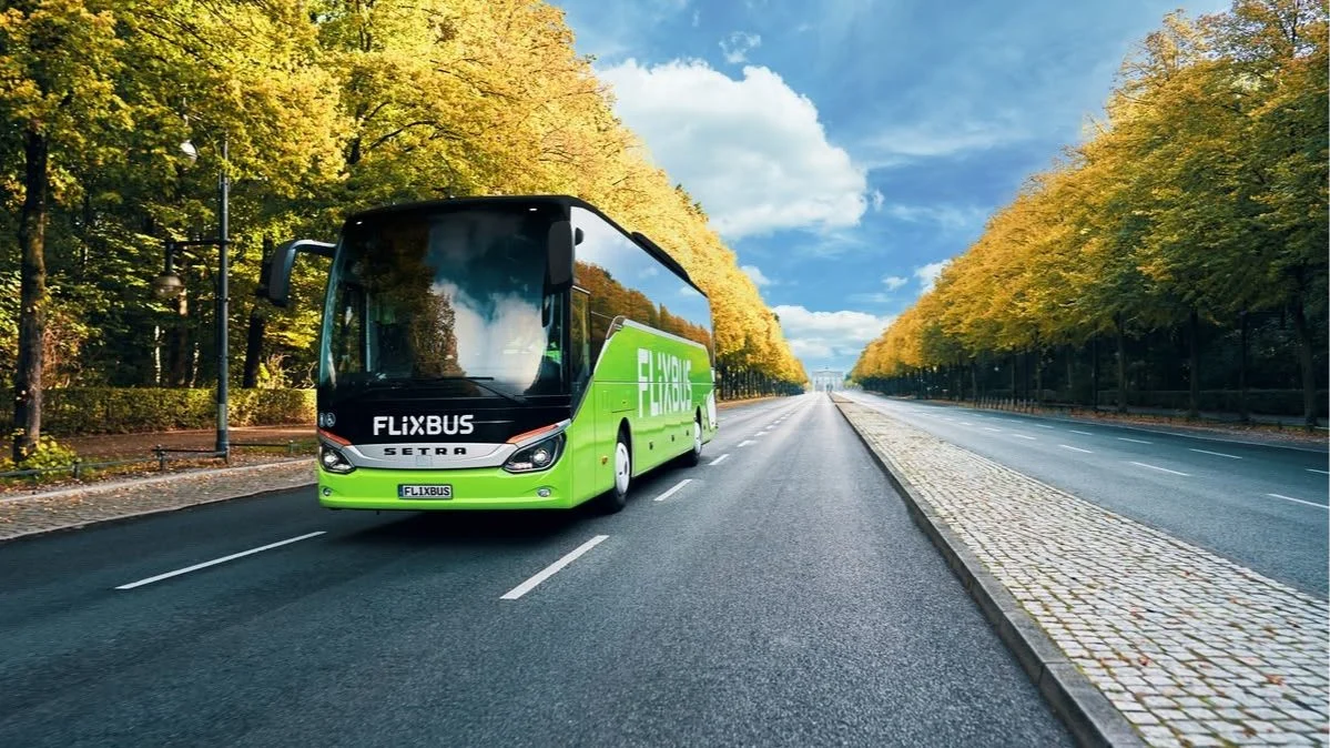 A green FlixBus coach travelling on a motorway, representing affordable travel and coach ticket savings across the UK.