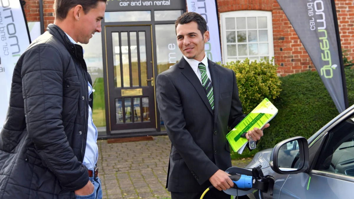Green Motion car hire service featuring a modern vehicle parked in a bright, professional urban centre setting.