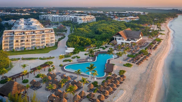 Modern H10 Hotels luxury resort exterior featuring a swimming pool and sun loungers for a relaxing holiday getaway.