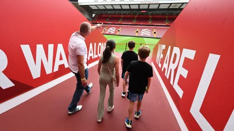 Panoramic view of the Anfield stadium pitch during a Liverpool Stadium Tour for football fans and visitors.
