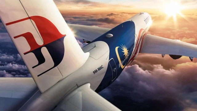 Malaysia Airlines aircraft flying above clouds, representing premium travel and international flight services.