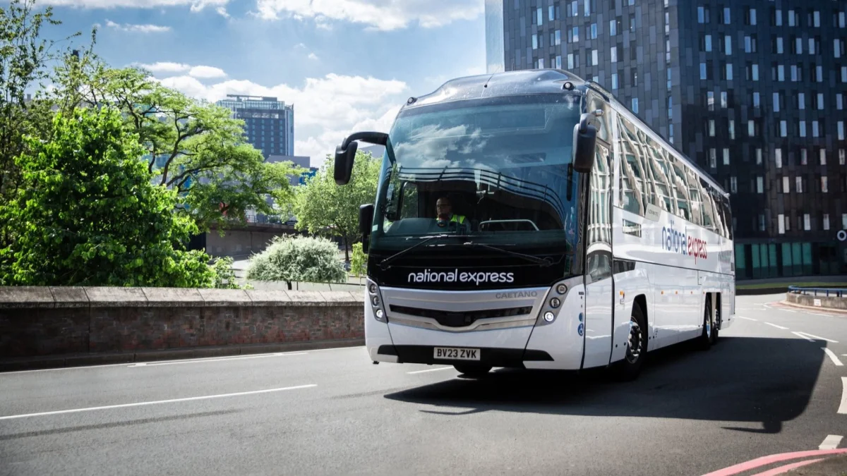 National Express coach travelling on a motorway, representing affordable UK travel and coach holiday transport services.