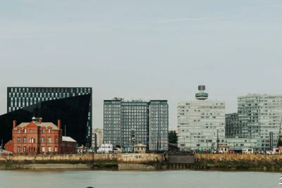 Modern Liverpool skyline featuring iconic waterfront architecture and the Liver Building under a clear blue sky.