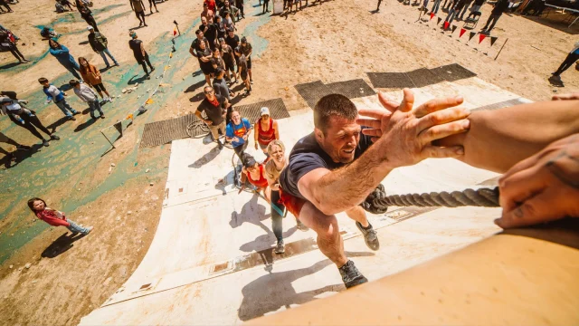 Participants tackling a challenging obstacle course at a Spartan Race event in the UK, showcasing fitness and endurance.