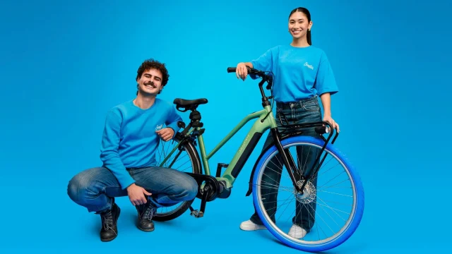 A blue Swapfiets bicycle parked on a city street, representing a convenient and sustainable subscription bike service.