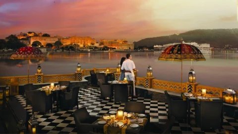Luxury exterior view of The Leela Palace hotel featuring elegant architecture and manicured gardens at twilight.