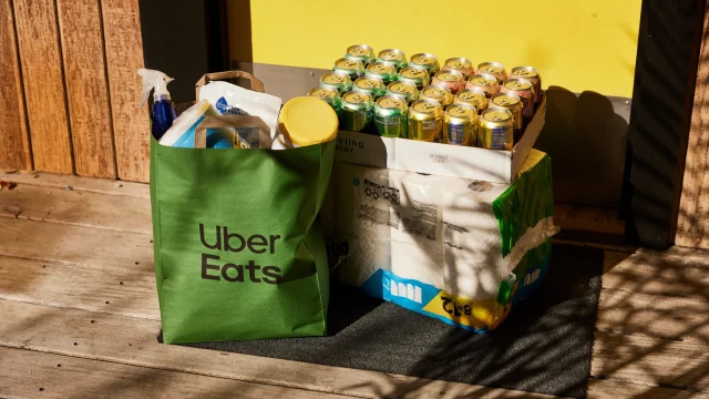 Uber Eats food delivery courier travelling on a bicycle through a city centre to deliver a takeaway meal.