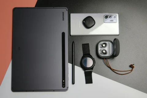 Samsung Galaxy ecosystem devices including smartphone, tablet, and smartwatch displayed on a clean, modern desk surface.