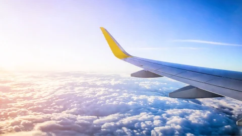 Vueling Airlines passenger aircraft parked at a European airport terminal during a sunny day for travel bookings.