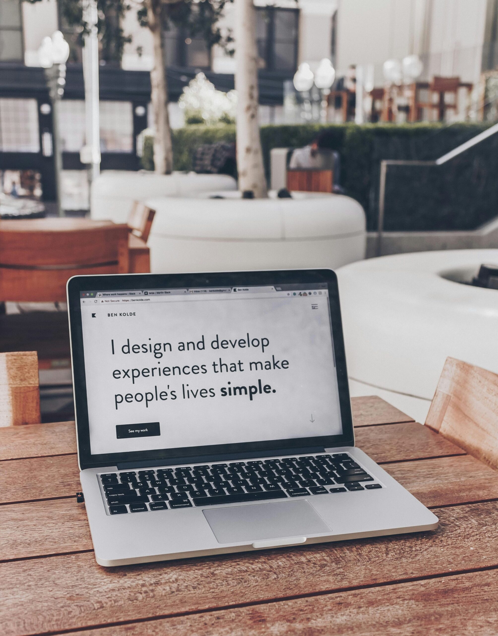 A clean creative portfolio website open on a laptop screen with coffee and notebook